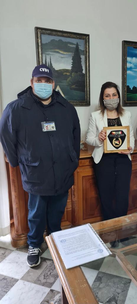 Il presidente Patellaro dell’associazione O.V. D.T.S. dona all’assessore Paola Naimi il loro stemma.